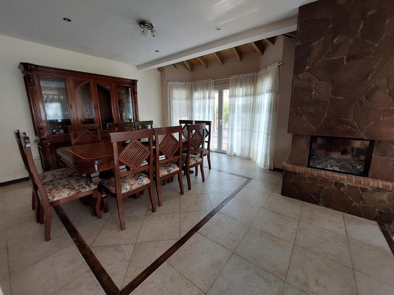 Comedor con mesa para ocho personas y hogar de piedra