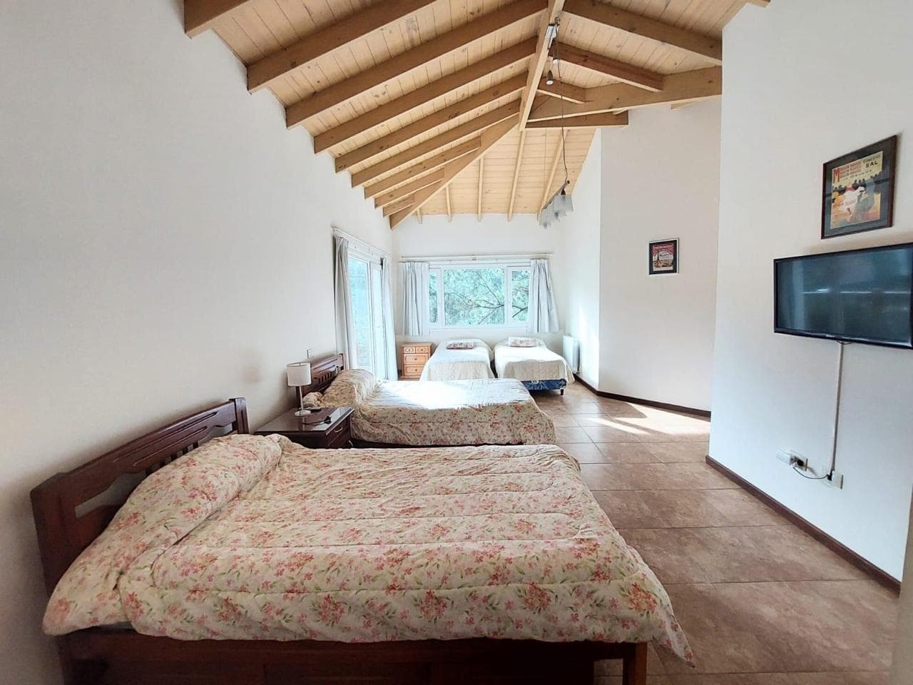 Dormitorio con techos a dos aguas y tres camas