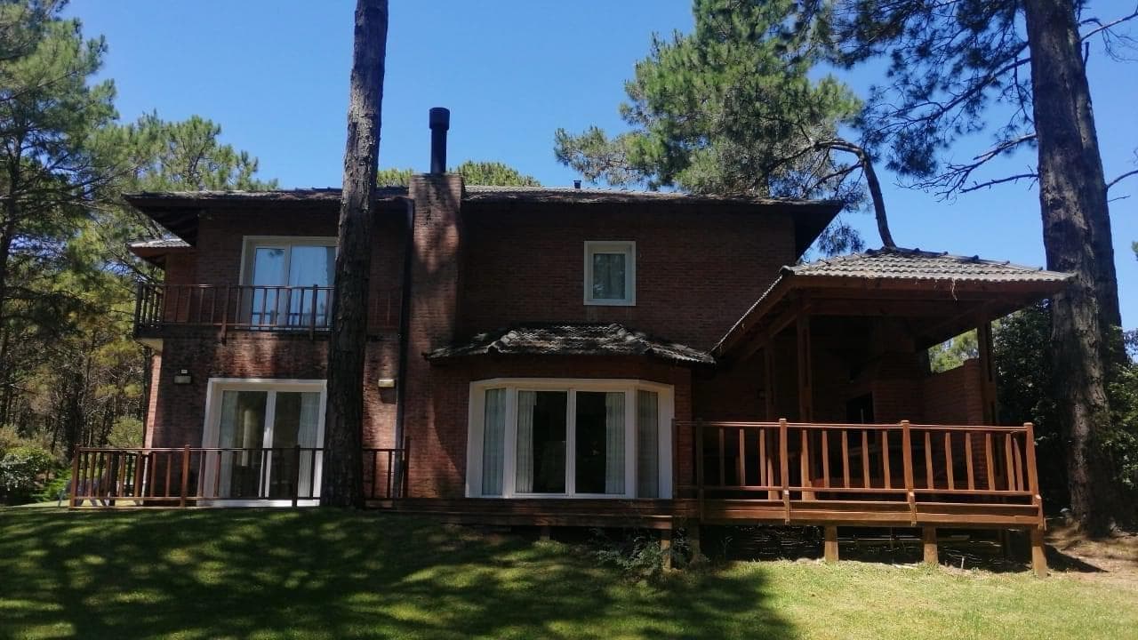 Parte trasera de la casa con balcón y deck de madera