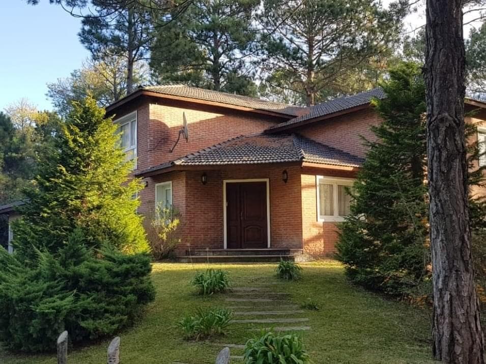 Fachada de Casa del Pinar vista desde el jardín, entre pinos